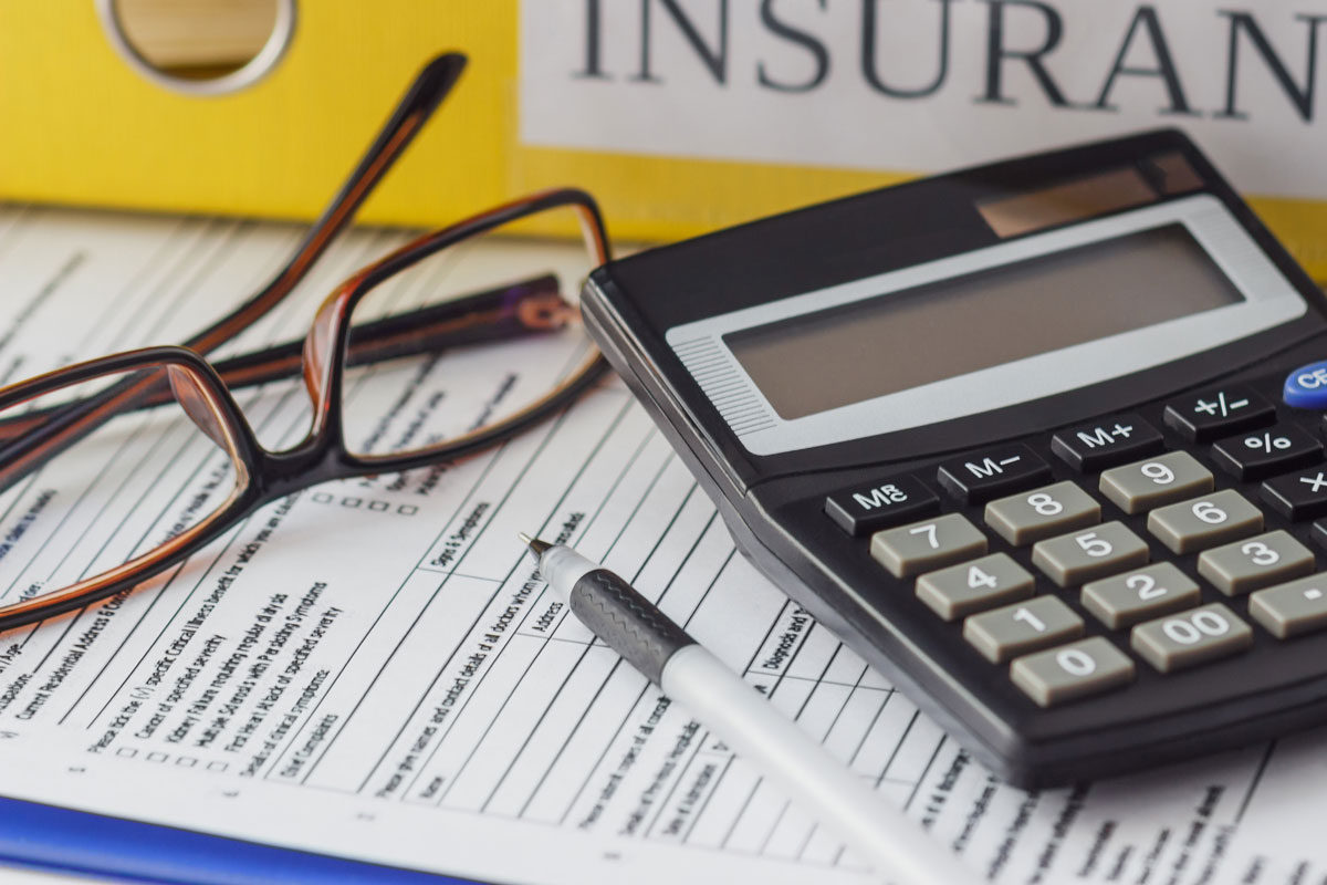 a pen, calculator, and glasses on top of a documents providing Commercial Insurance in Alameda, San Leandro, Santa Clara, Berkeley, Hayward, CA, Fremont